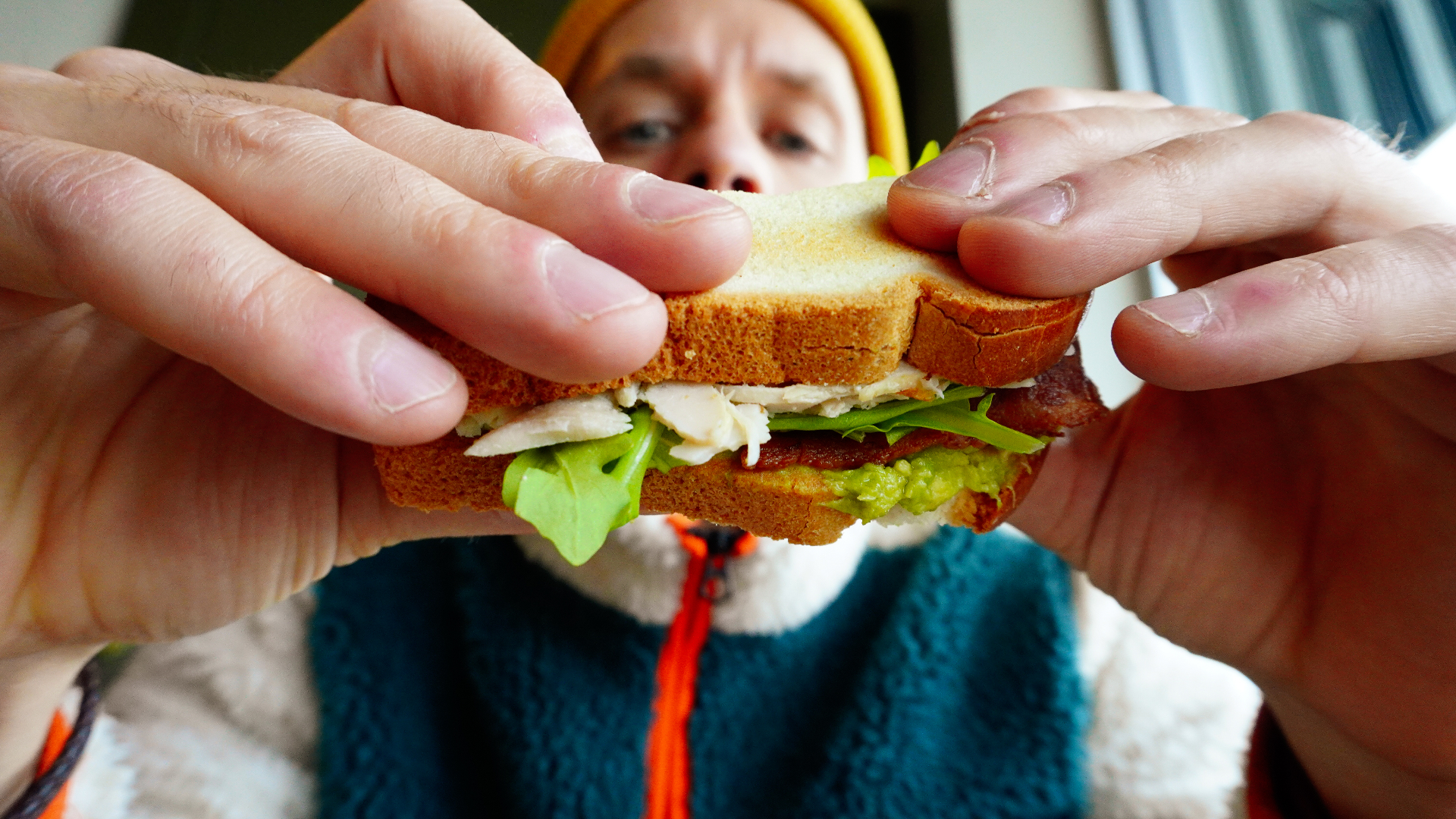Hands holding a freshly made sandwich